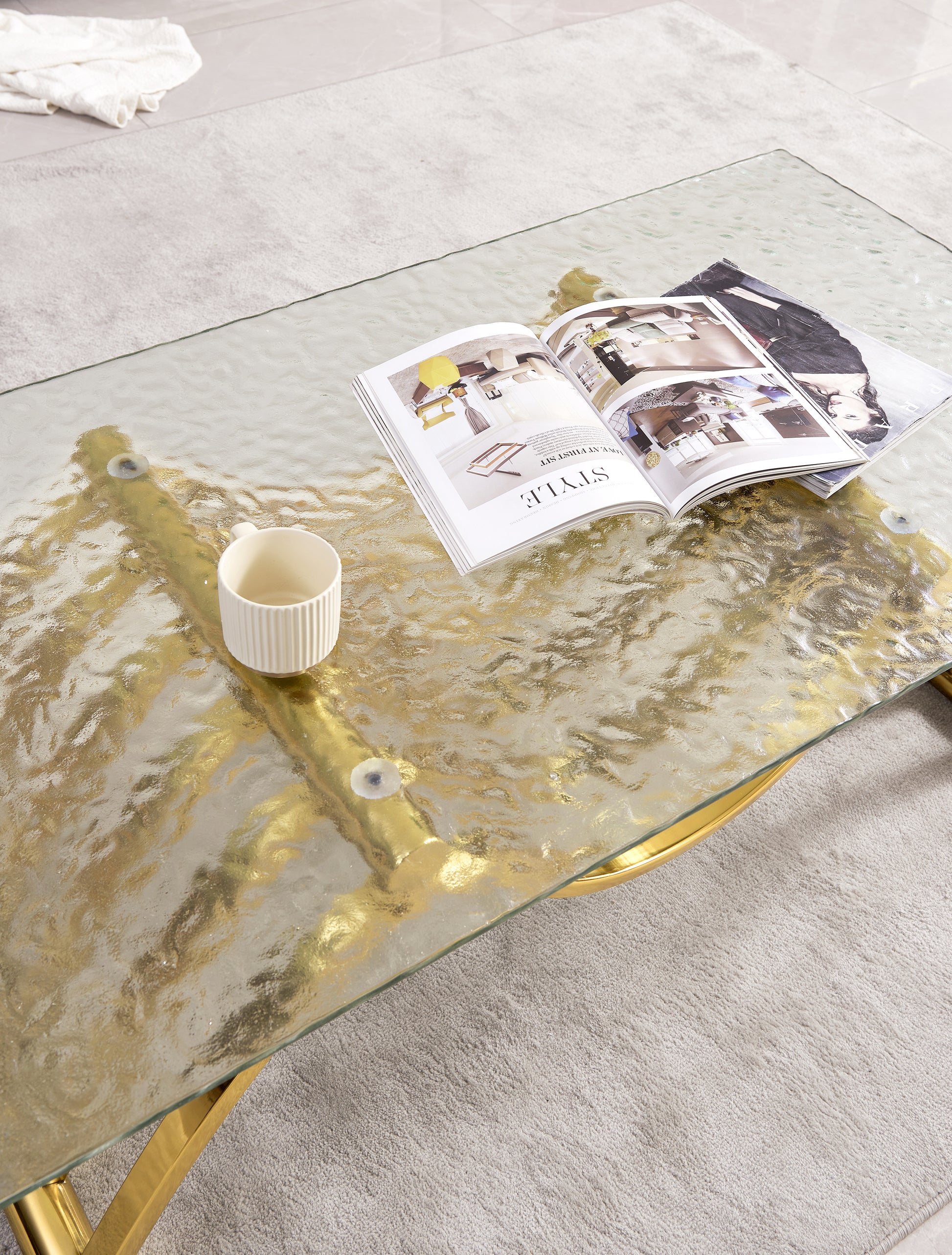 Glass coffee table with gold accents and textured top