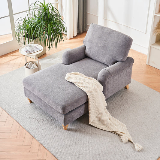 Grey fabric chaise lounge with accent pillows and throw blanket