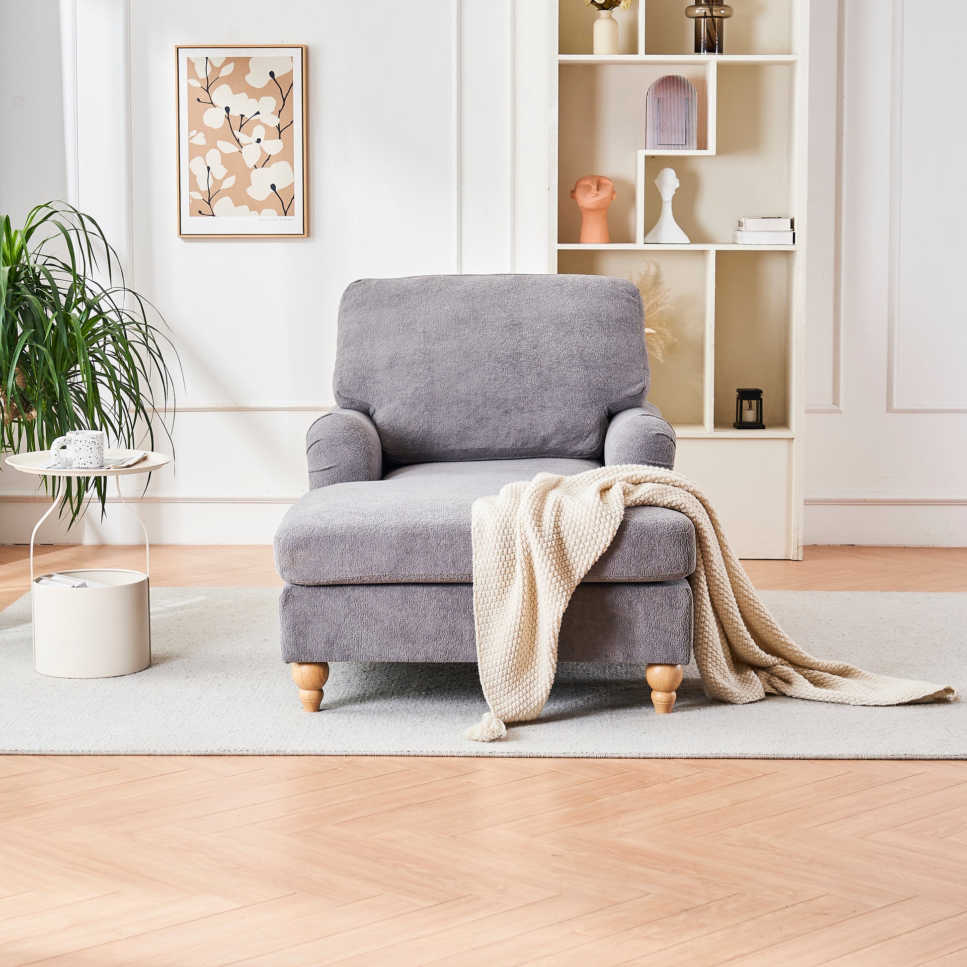 Gray fabric accent chair with wooden legs and a cream knitted throw