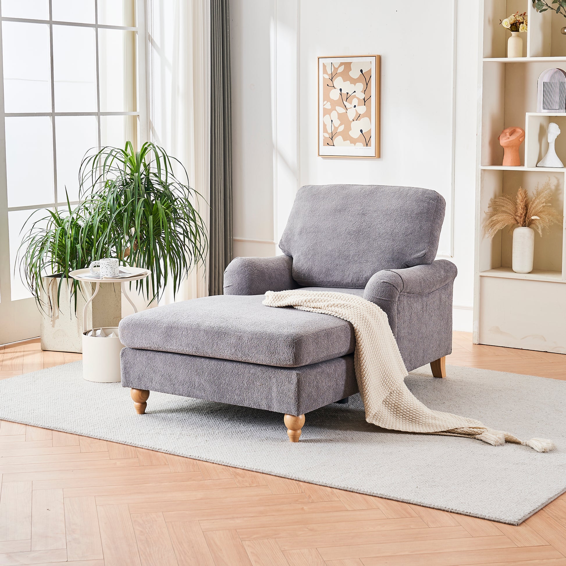 Grey plush chaise lounge with light knit throw