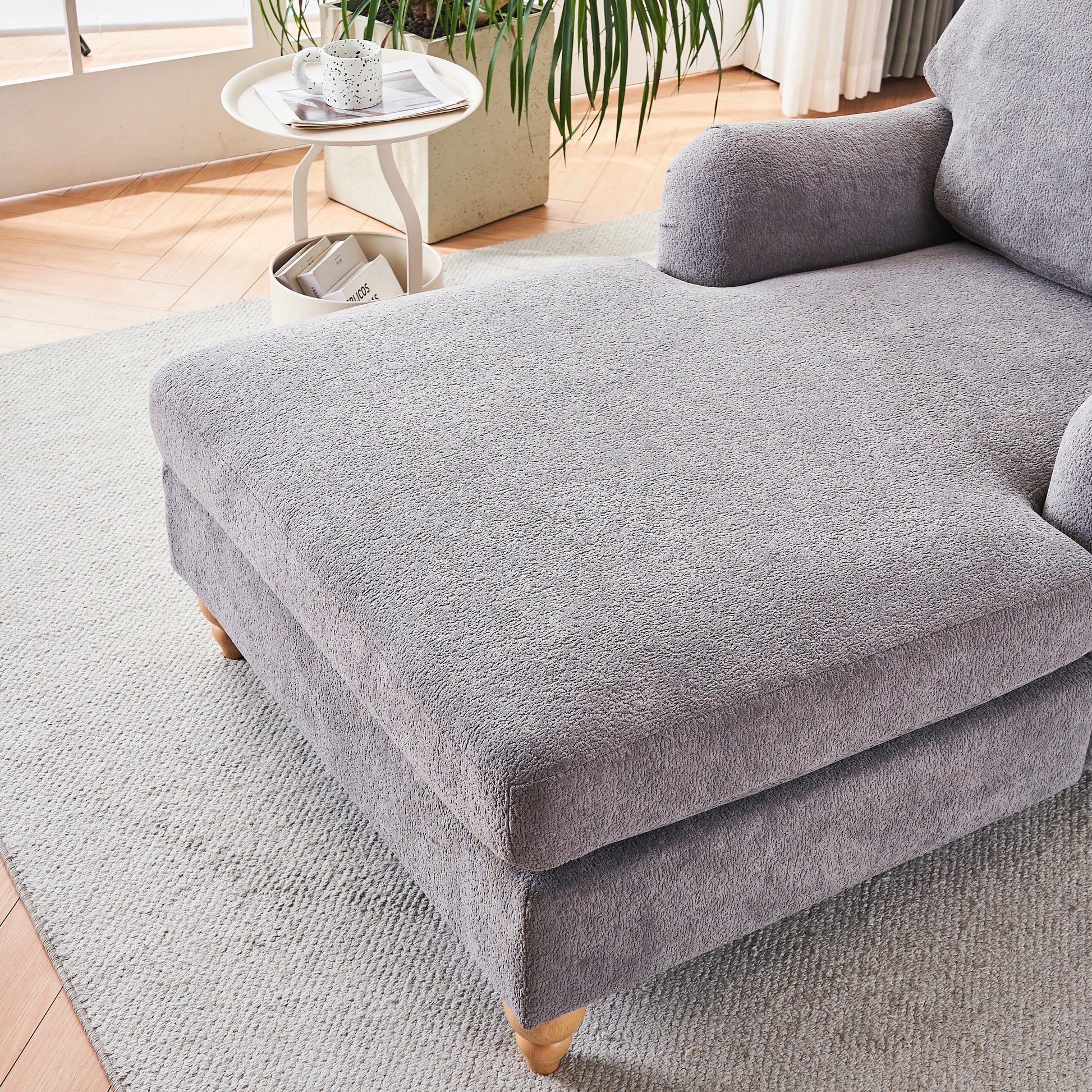 Cozy grey textured sofa with plush fabric and wooden legs