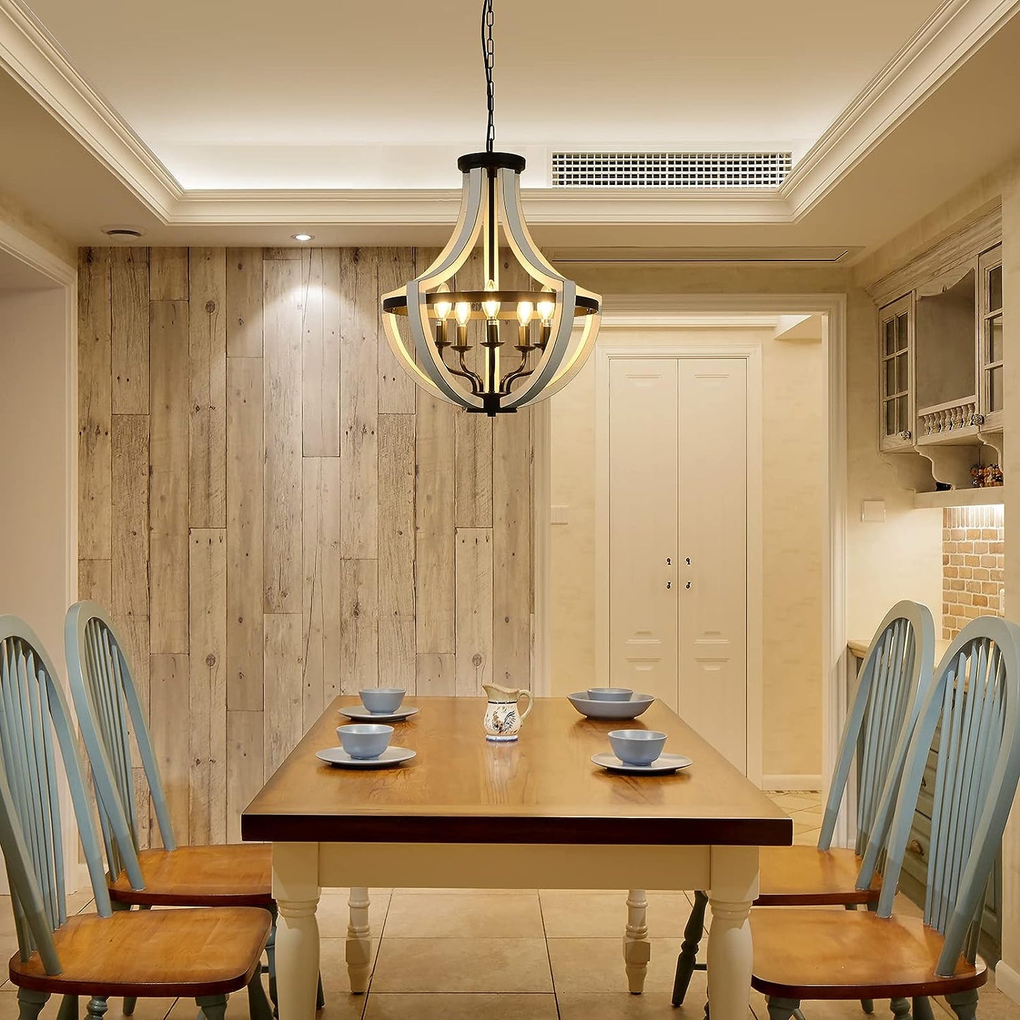 Farmhouse chandelier with distressed wood and black metal accents in dining room