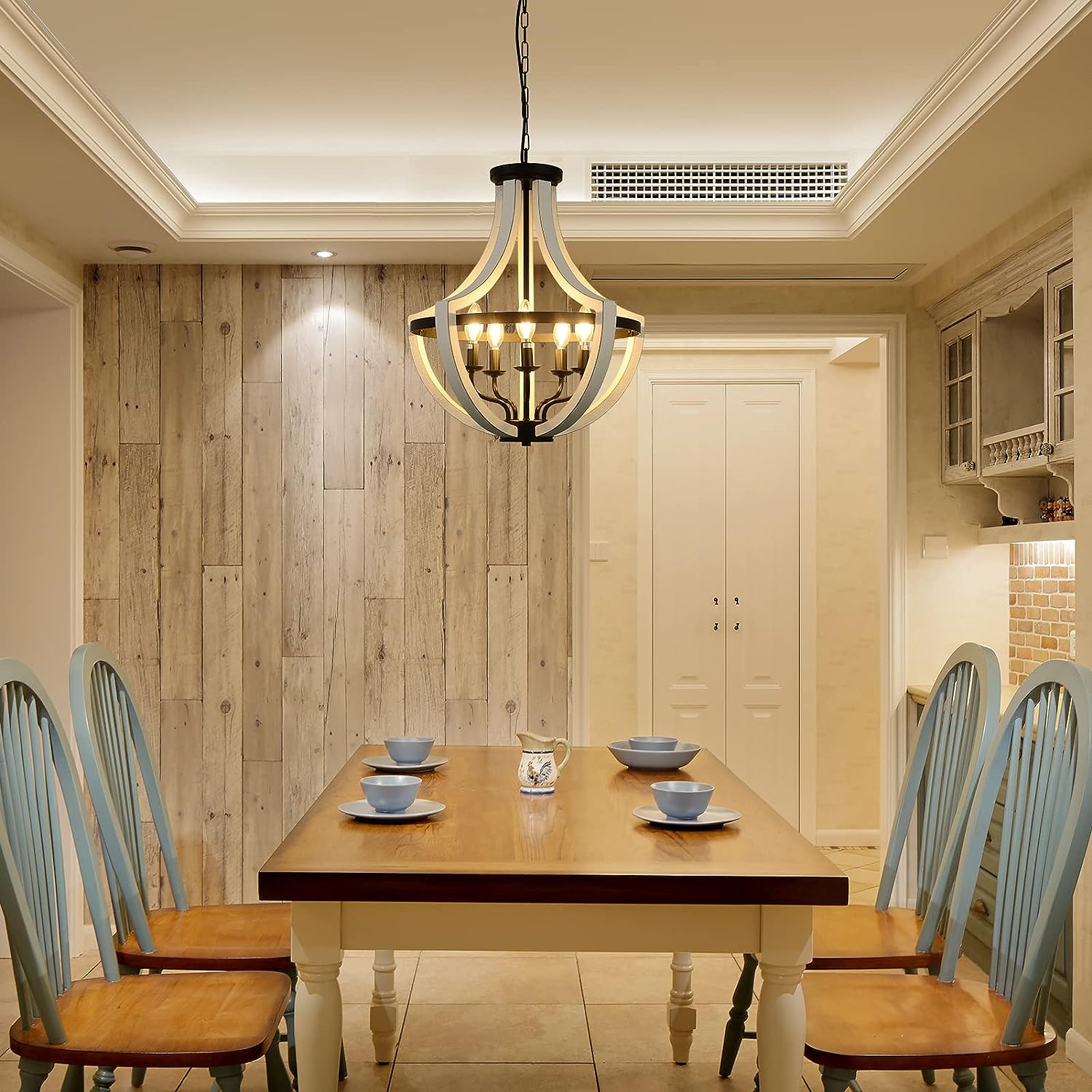 Farmhouse chandelier with distressed wood and black metal accents in dining room