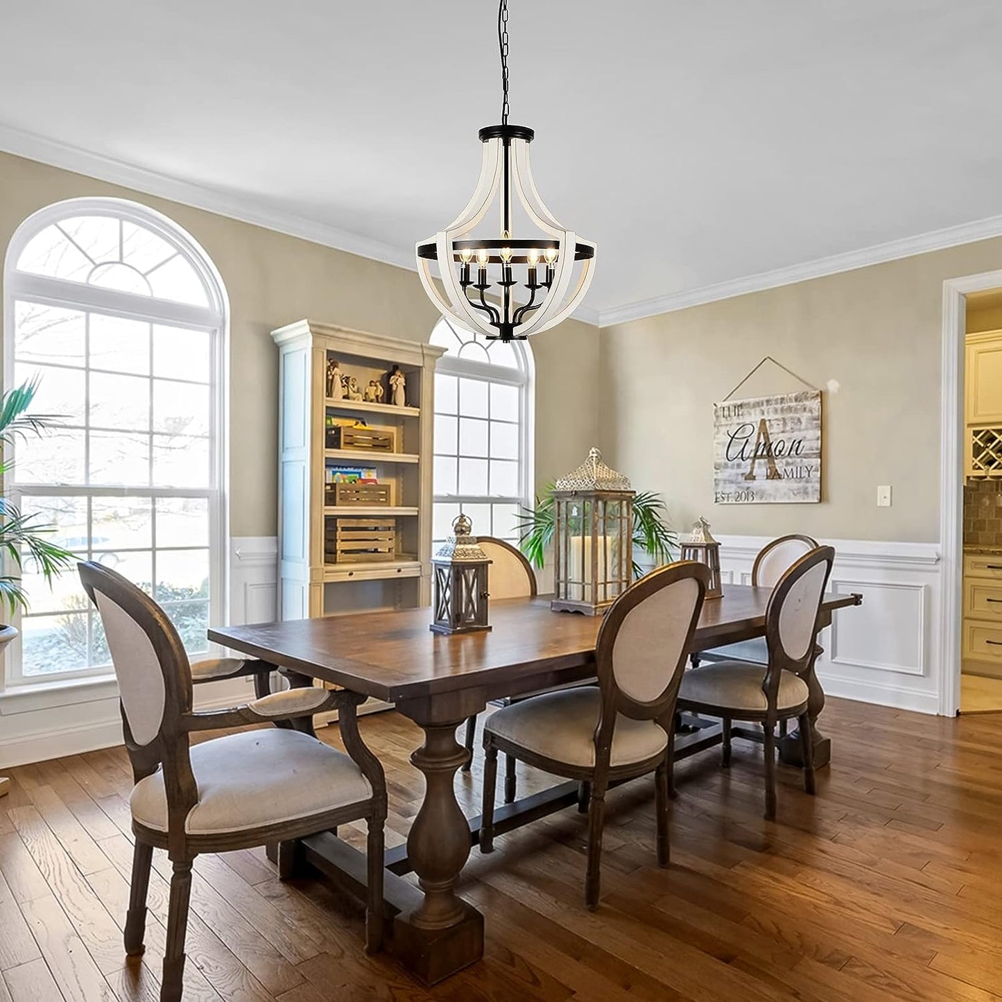 Rustic tiered chandelier with white wood and black metal accents over dining table