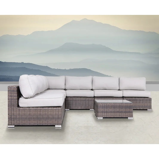 Gray wicker sectional sofa with white cushions and glasstop coffee table