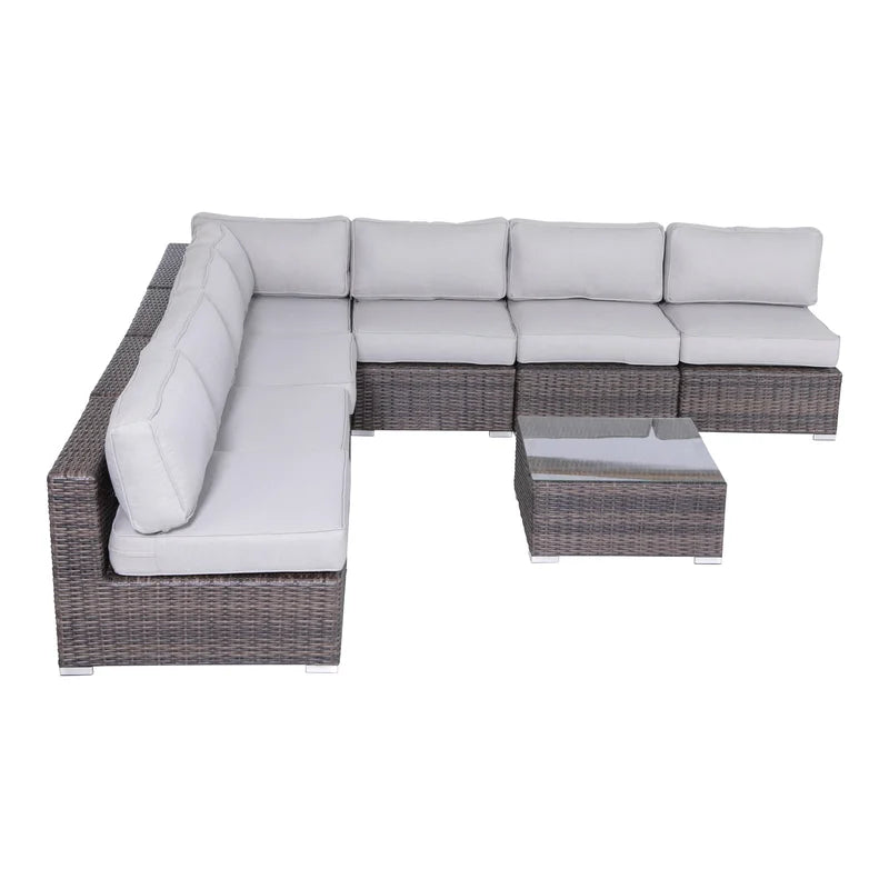 Wicker sectional sofa with light gray cushions and glasstop coffee table