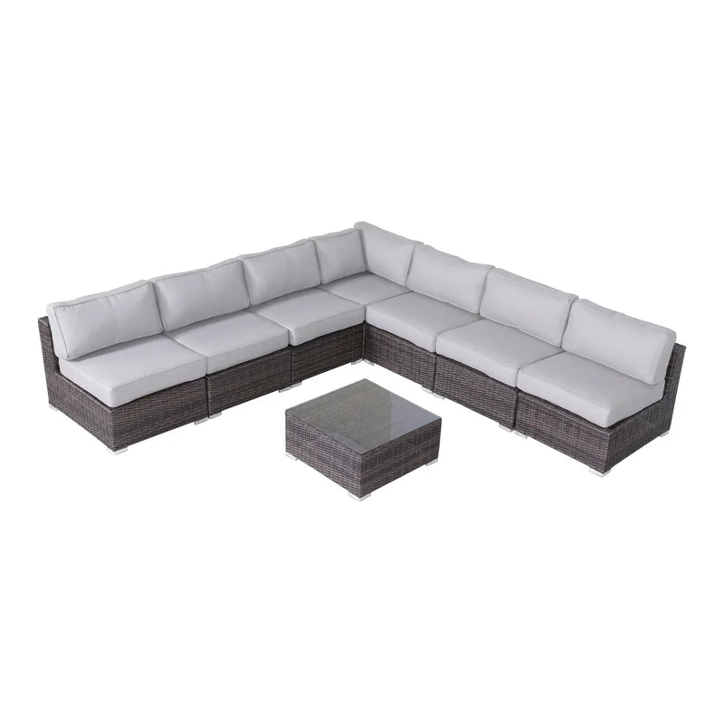 Brown rattan sectional sofa with light gray cushions and glasstop coffee table