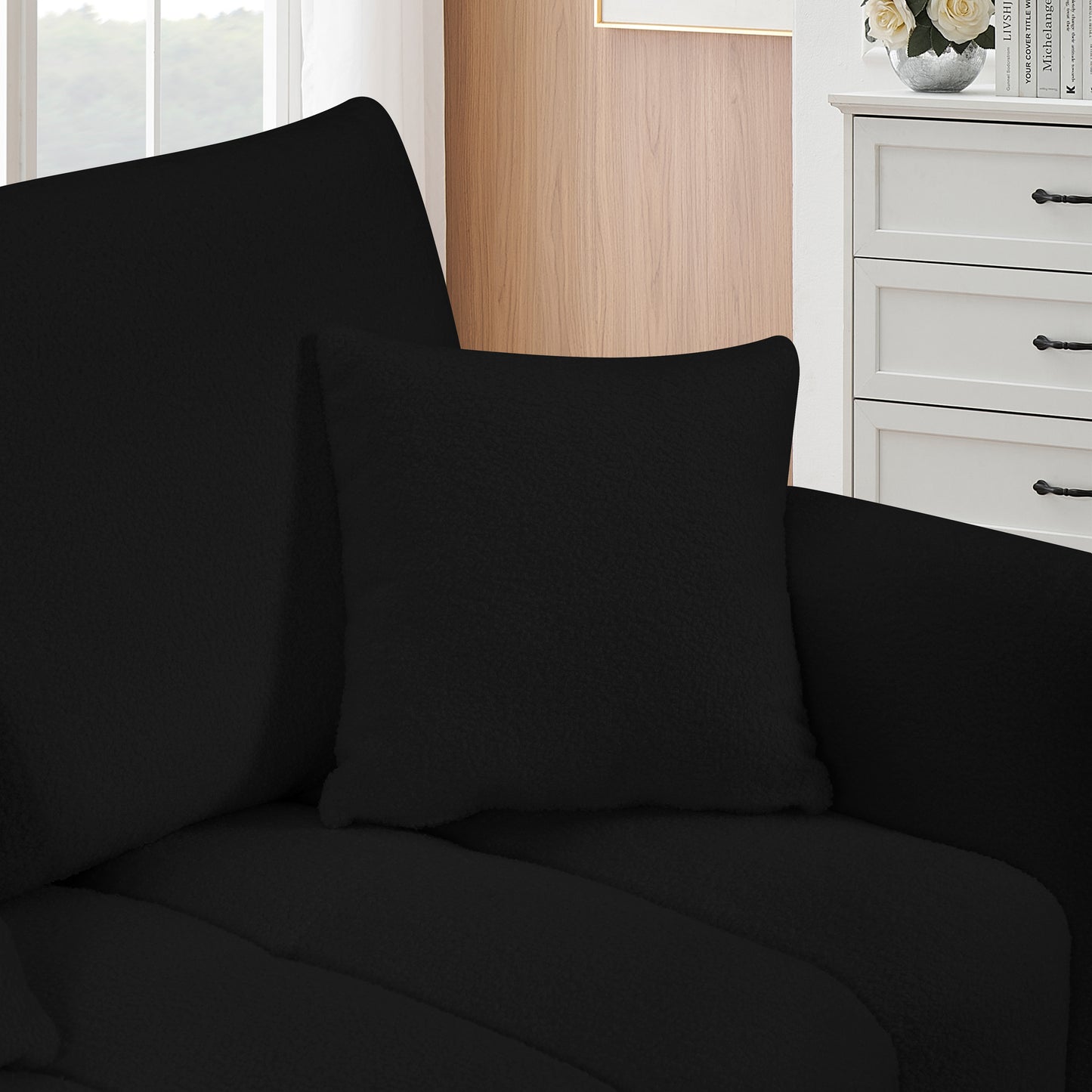 Black textured throw pillow on a modern sofa