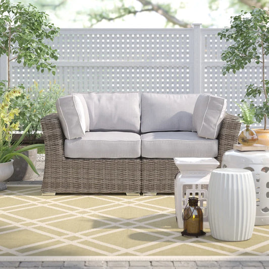 Gray wicker loveseat with plush cushions