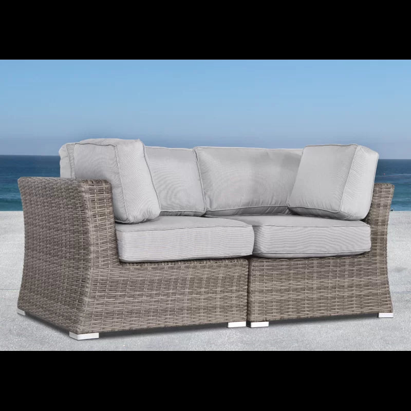 Gray wicker sectional sofa with plush cushions on a patio