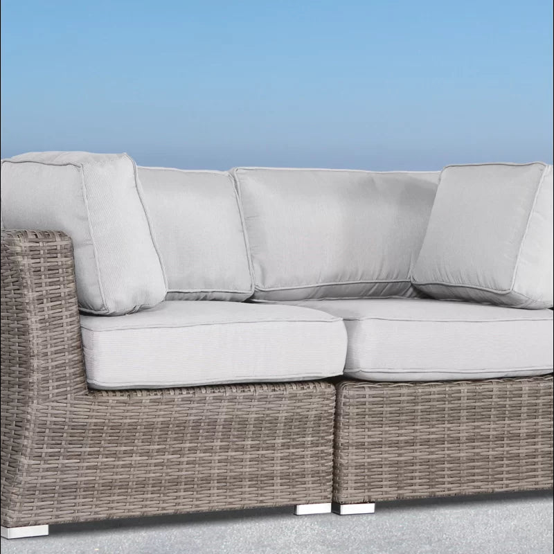 Grey rattan sectional sofa with plush white cushions