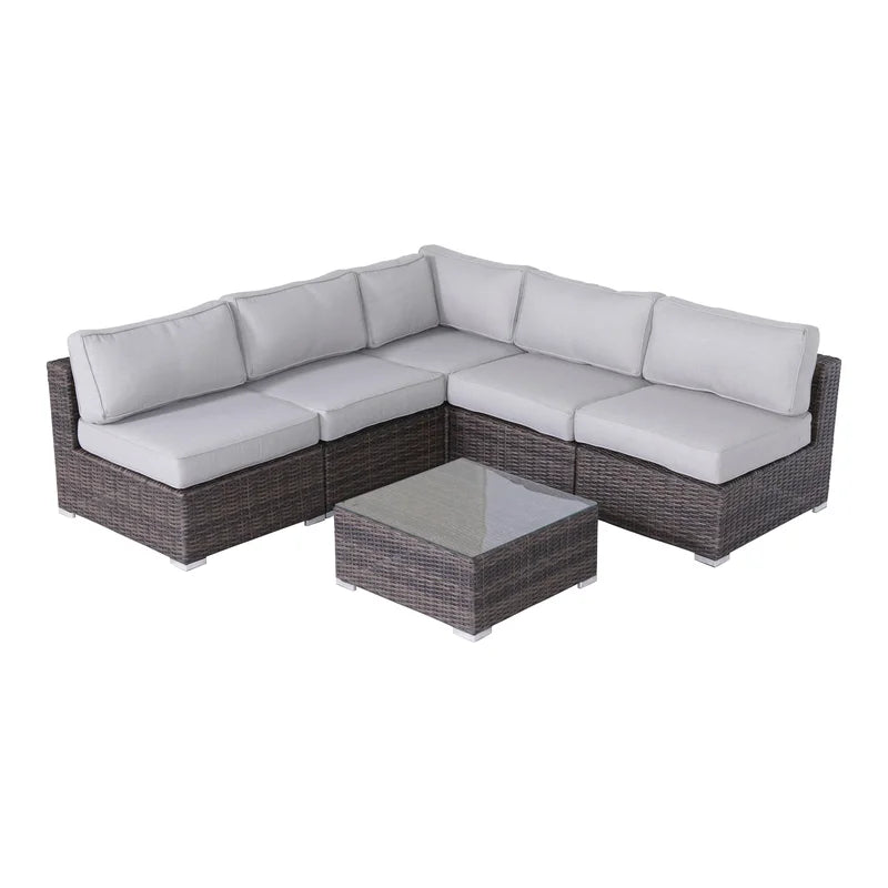 Brown wicker sectional outdoor sofa with gray cushions and glasstop coffee table