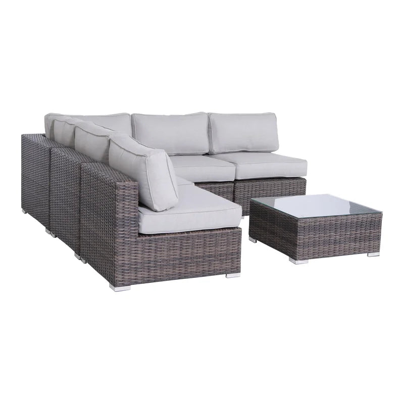 Gray sectional outdoor sofa with brown wicker base and glasstop coffee table