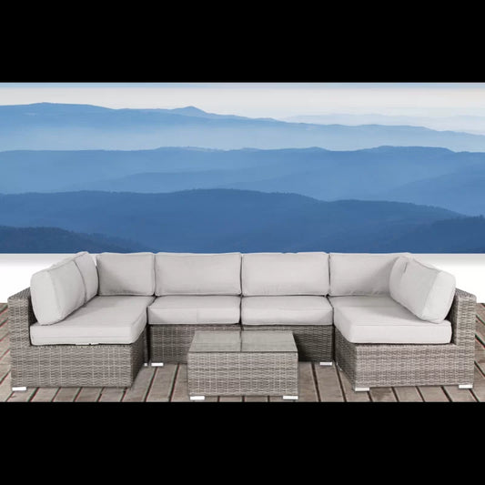 Grey wicker sectional sofa with light grey cushions and glasstop coffee table