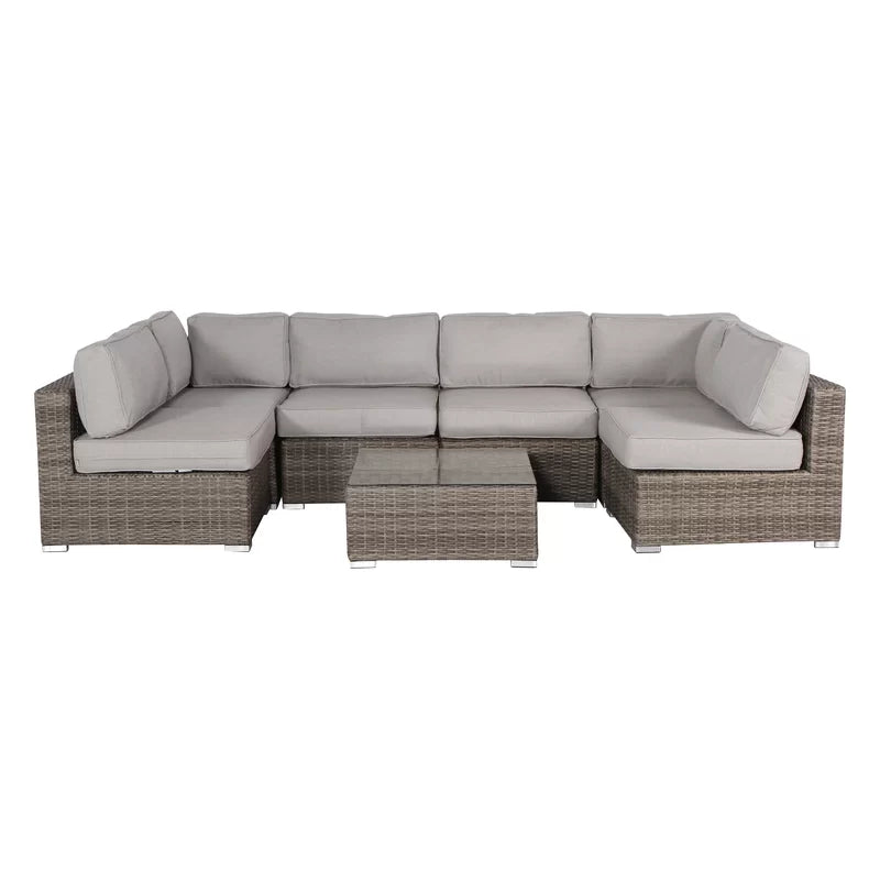 Gray wicker sectional sofa with light cushions and glasstop coffee table