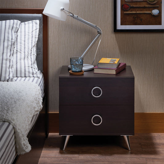Dark wood nightstand with silver ring pulls beside a bed
