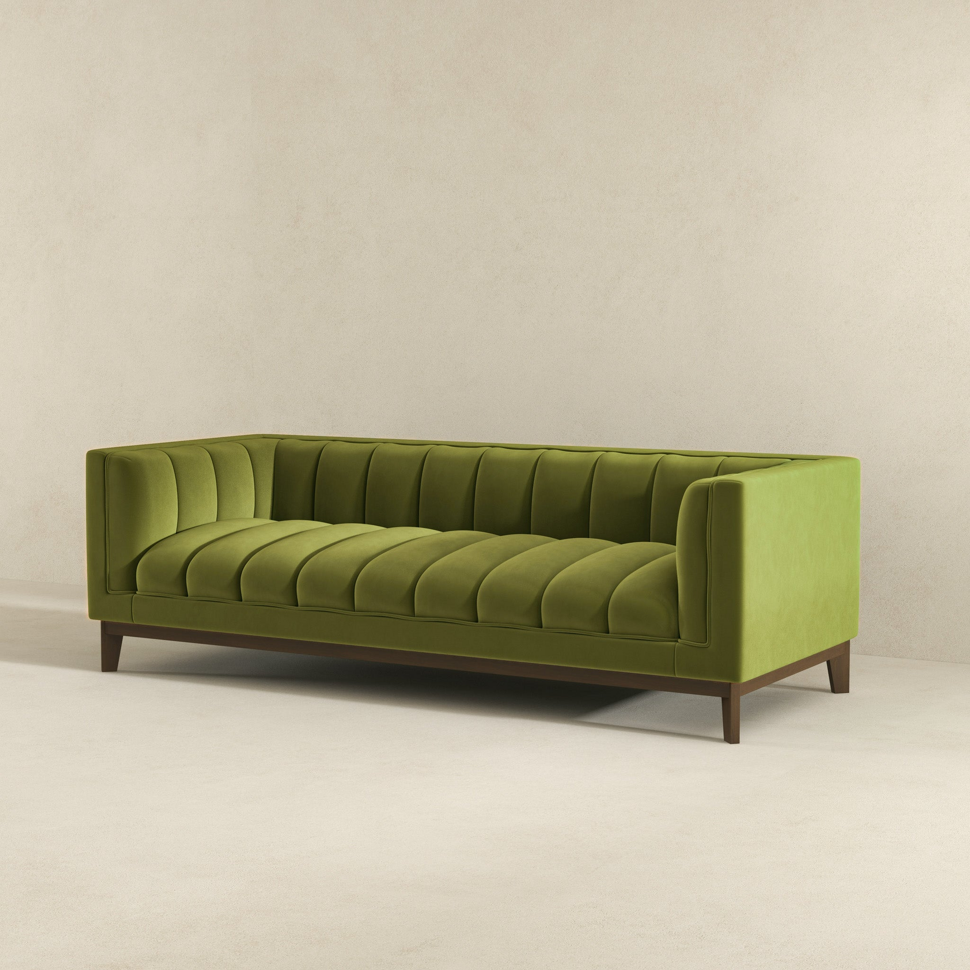 Green velvet sofa with channel tufting and dark wood legs