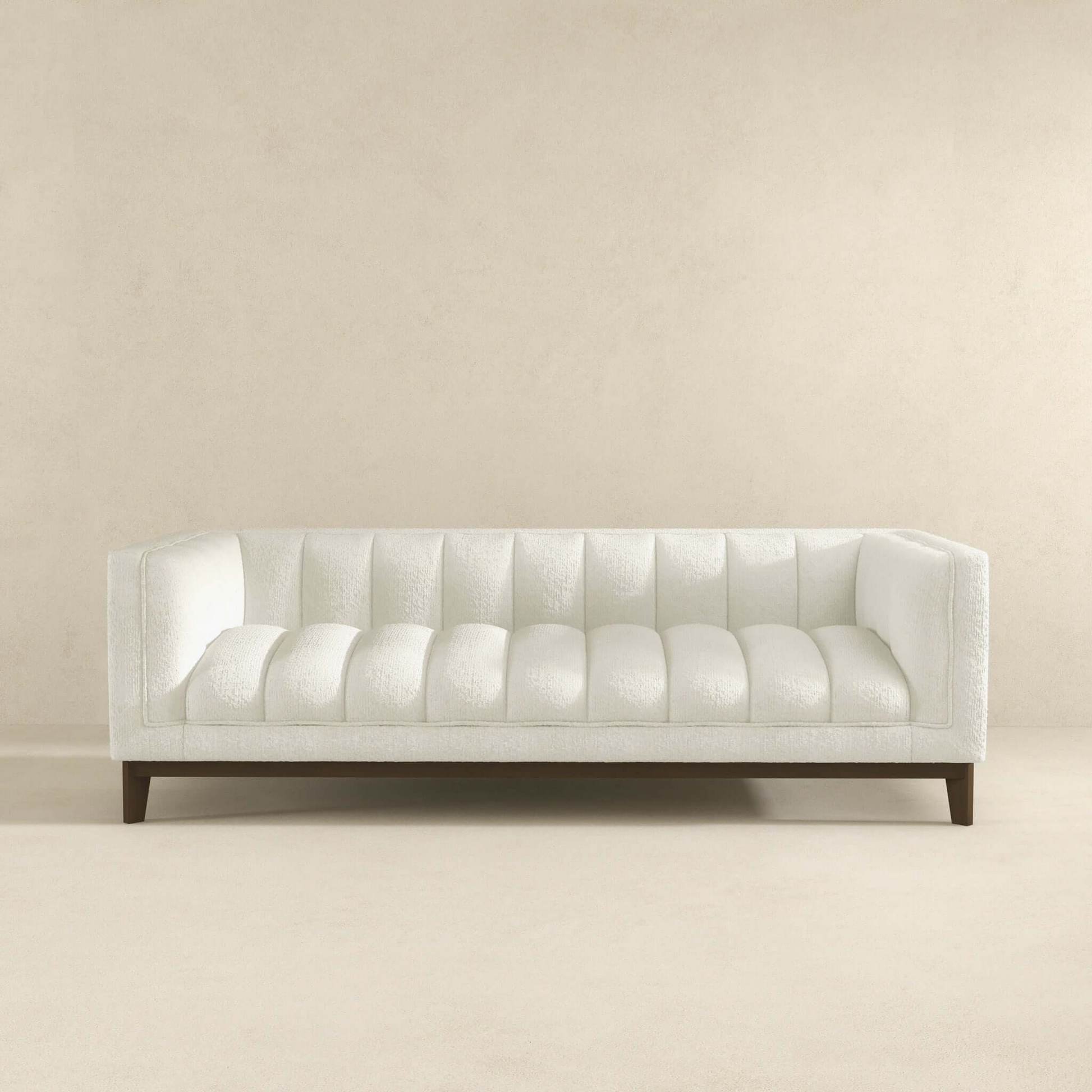 White boucle sofa with channel tufting and dark wood legs