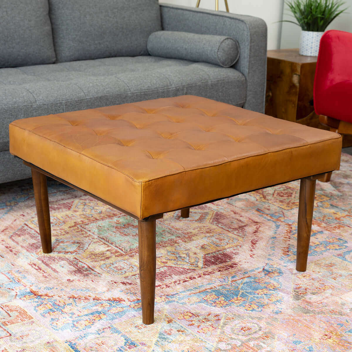 Tan leather tufted square ottoman with dark wood legs