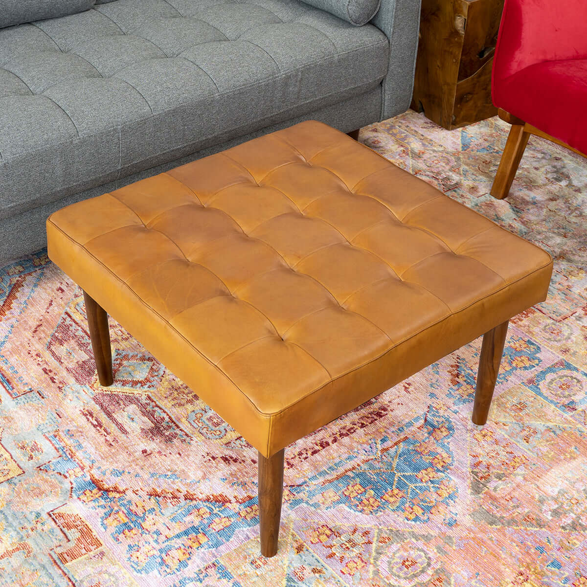 Brown leather tufted ottoman with wooden legs