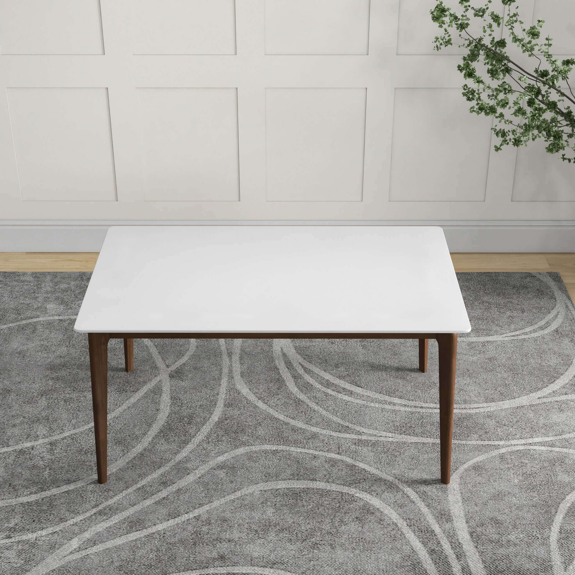 Rectangular white coffee table with tapered wooden legs on a grey patterned rug