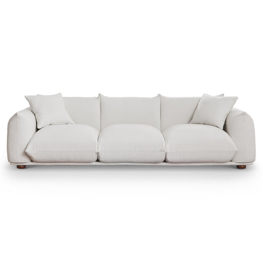 Plush white boucl fabric threeseater sofa with curved arms and modern wood feet