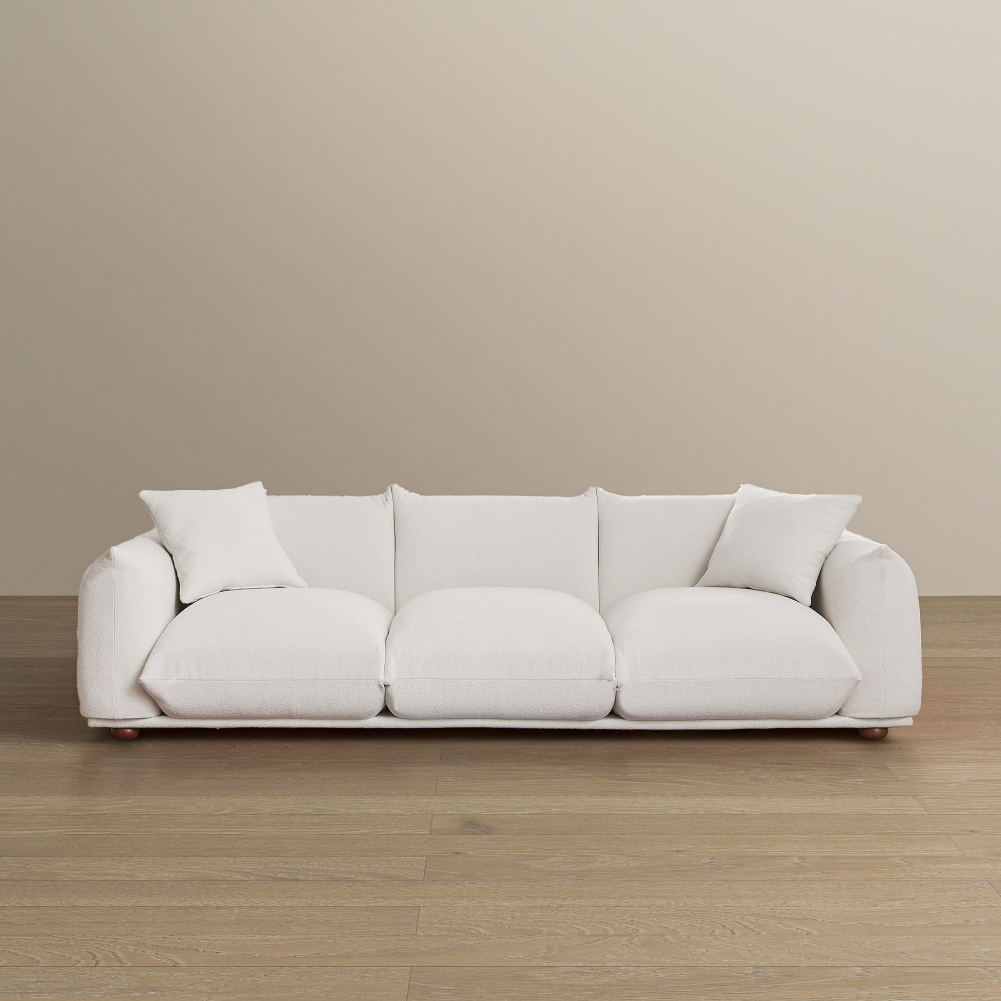 Plush white boucle sofa with deep seats and two decorative pillows