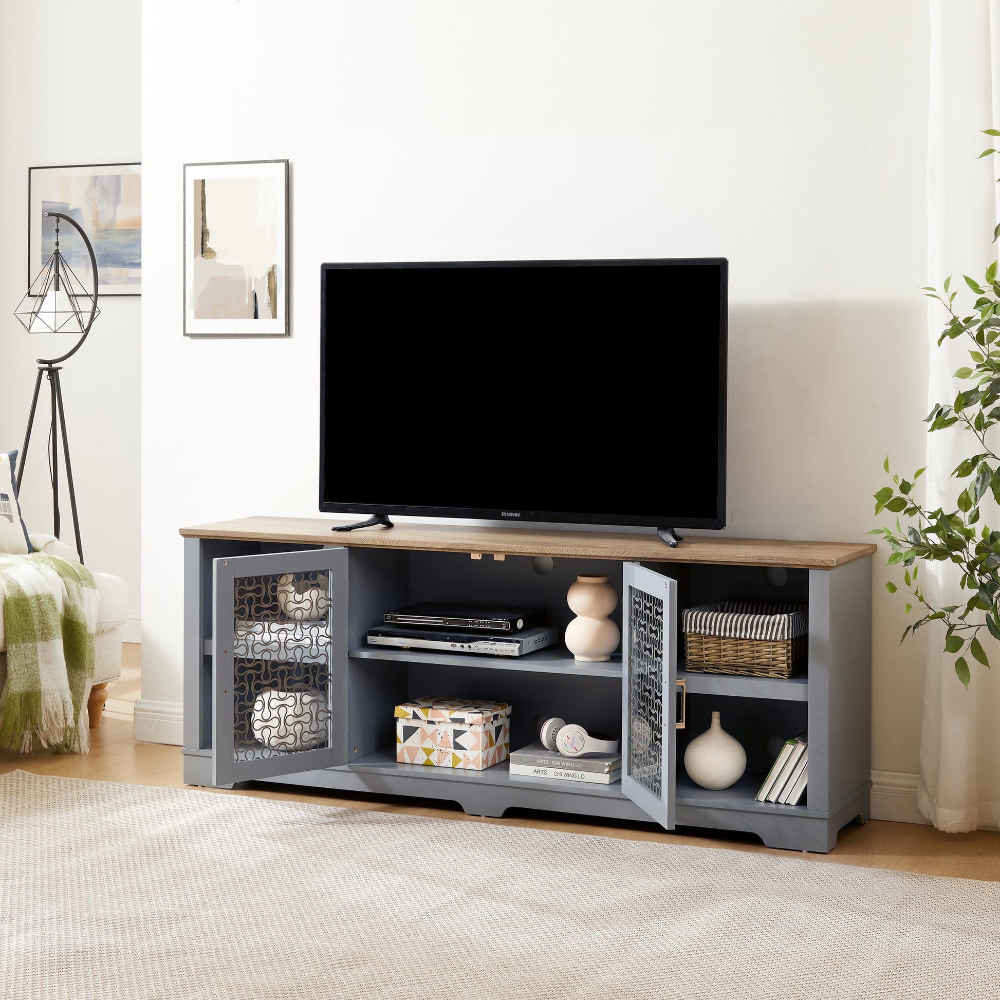 Grey media console with oak top and glass doors displaying decorative items