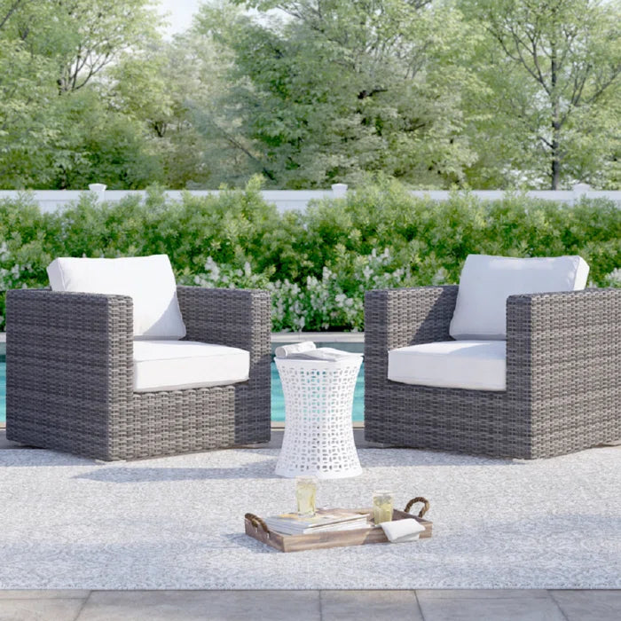 Charcoal wicker armchair with white cushions for patio relaxation