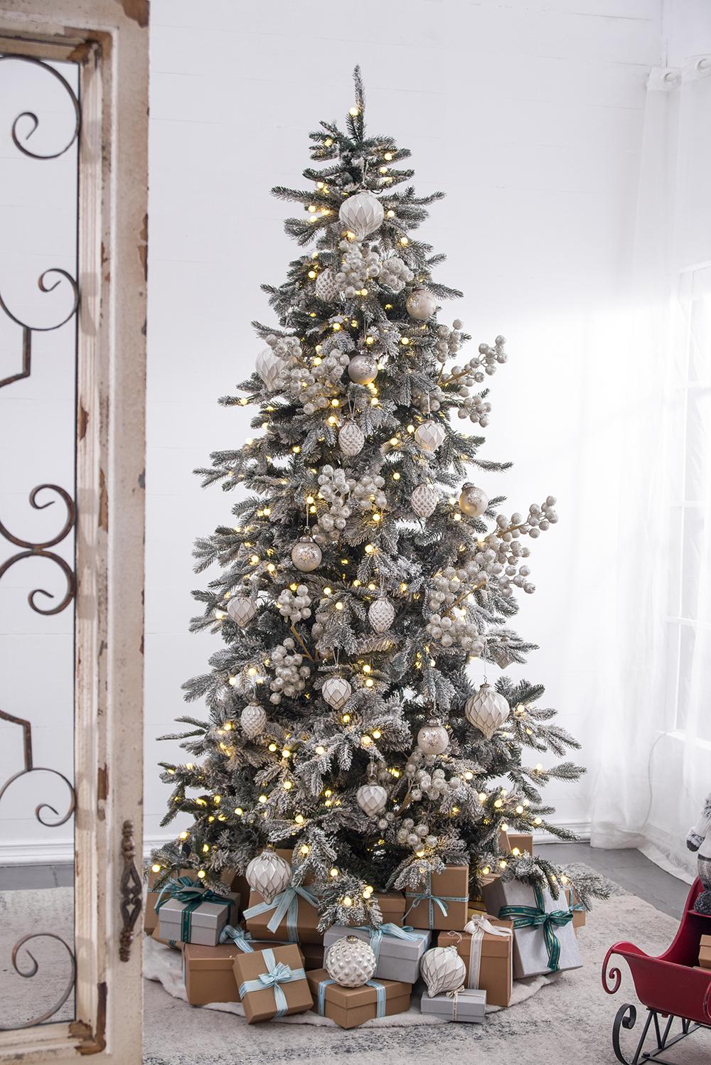 Flocked artificial Christmas tree with white ornaments and warm LED lights