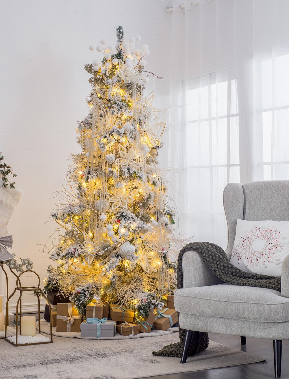 Flocked artificial Christmas tree with warm white lights and ornate white ornaments