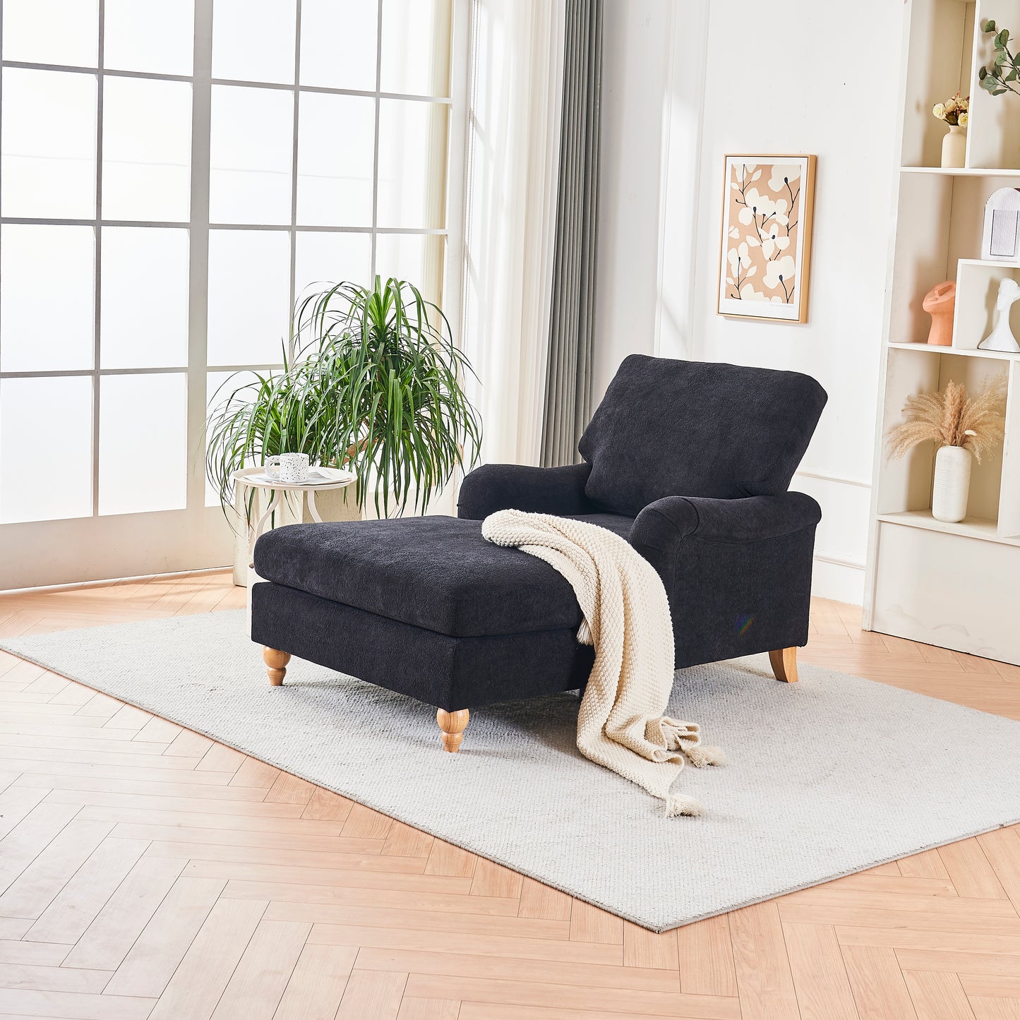 Dark grey fabric chaise lounge with wooden legs and cream throw blanket