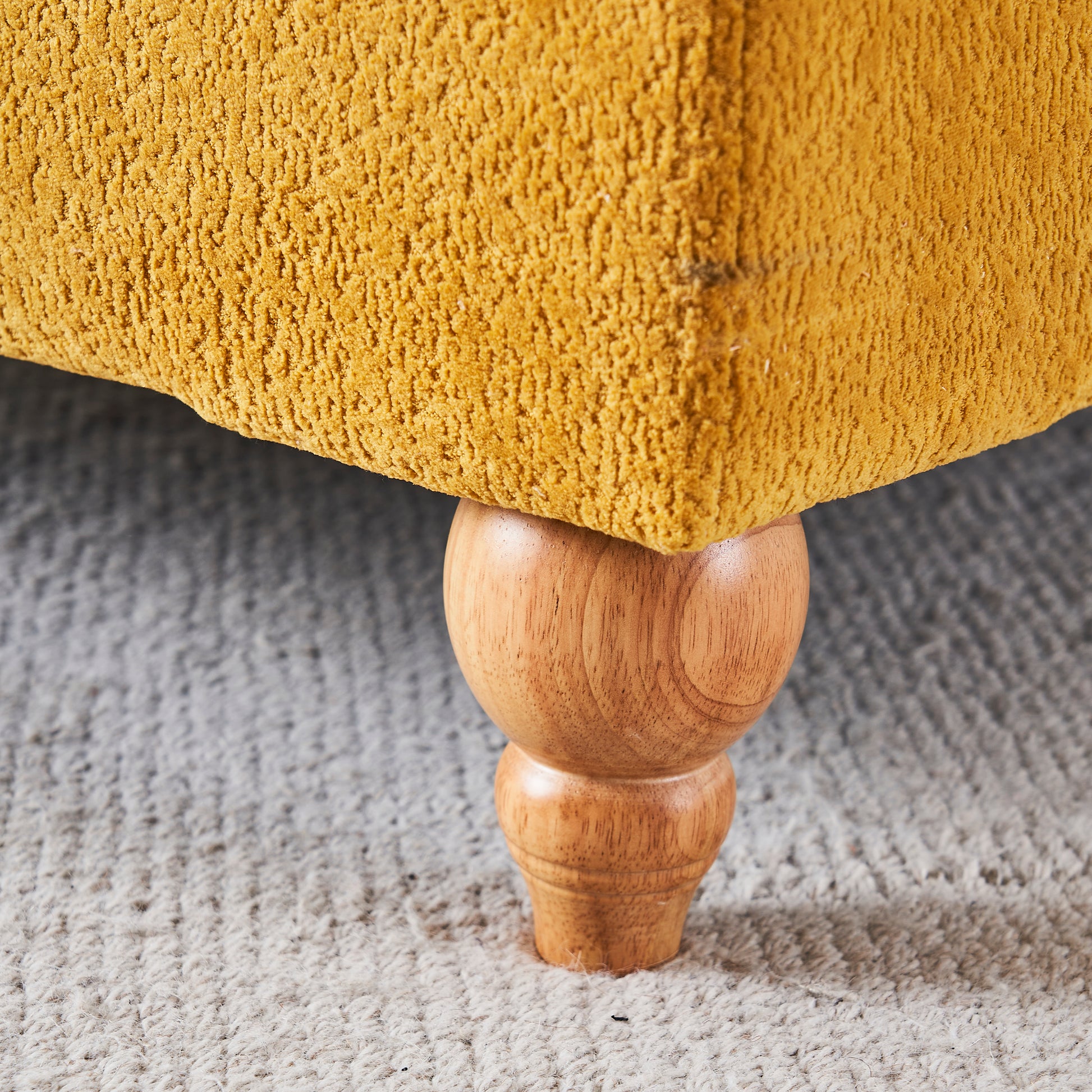 Textured mustard yellow fabric sofa with turned wooden legs