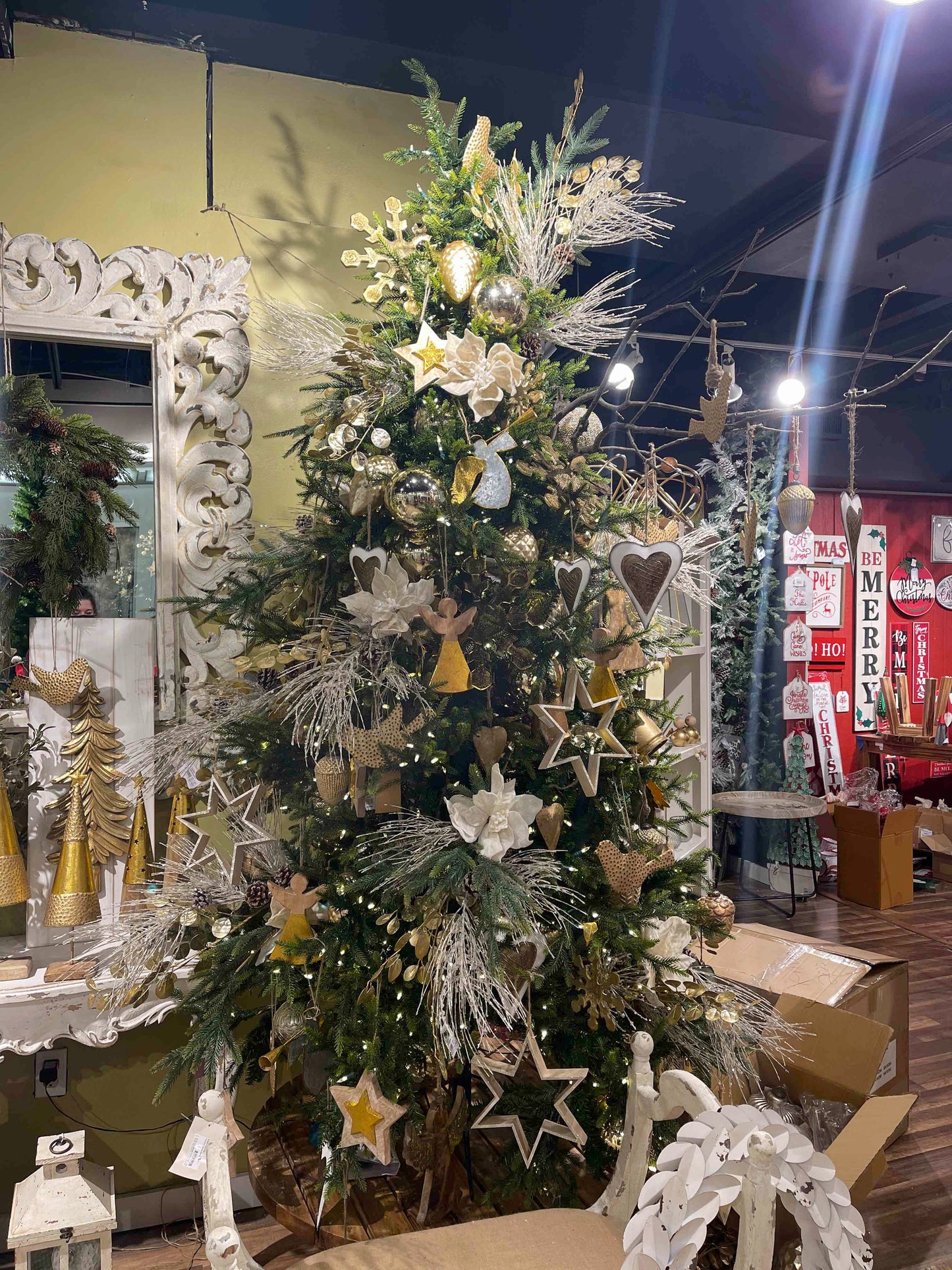 Luxurious Christmas tree adorned with gold stars and white flowers