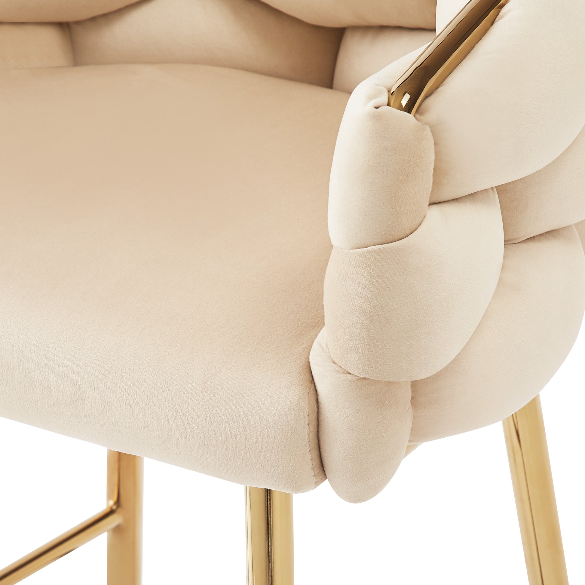 Plush cream velvet armchair with gold armrest accents and braided detail
