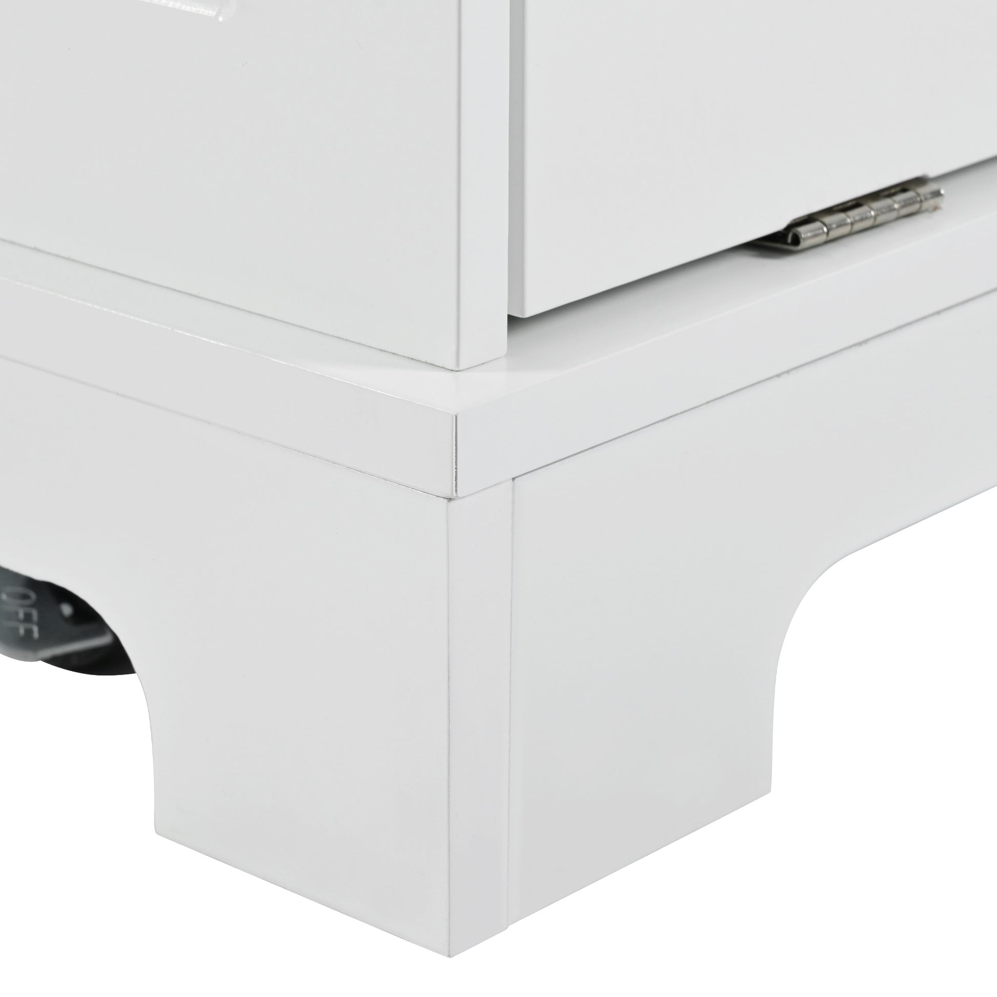 Closeup of a white storage cabinet corner with brushed metal hinge