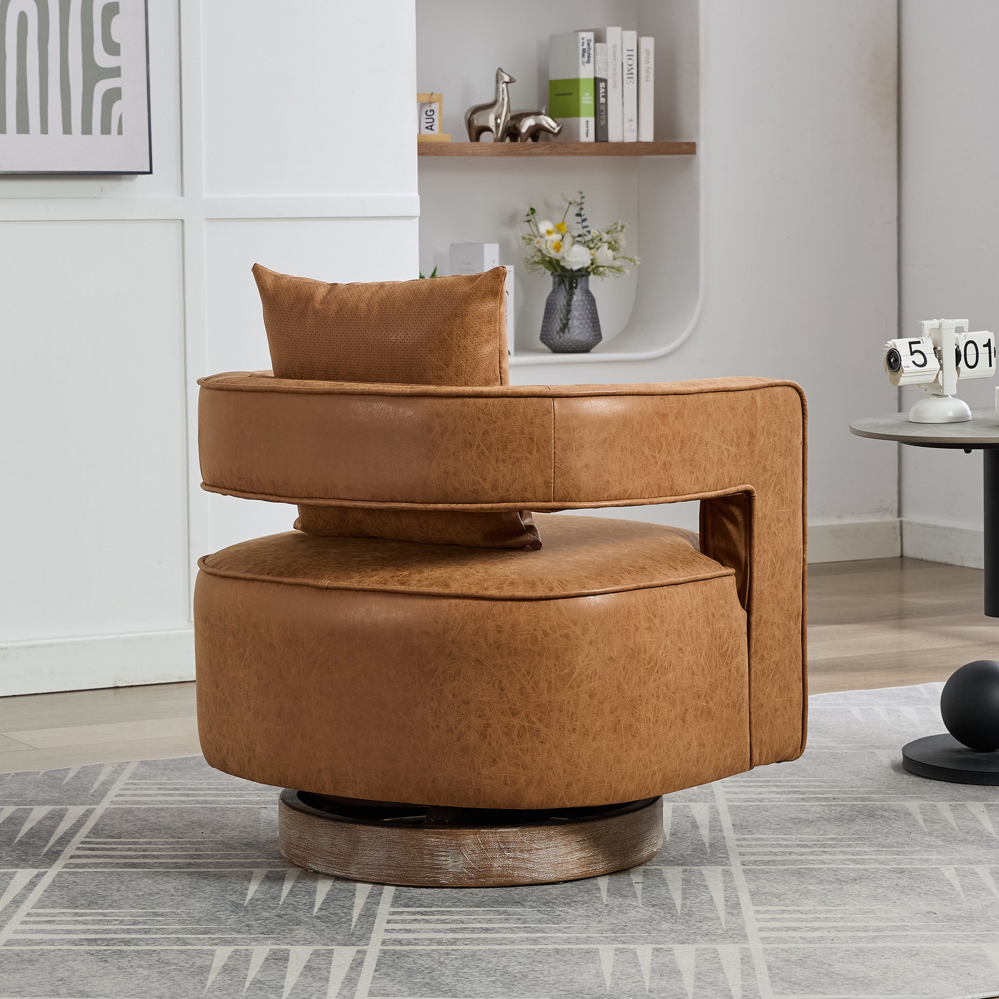Tan leather swivel accent chair with plush cushions and a distressed wood base