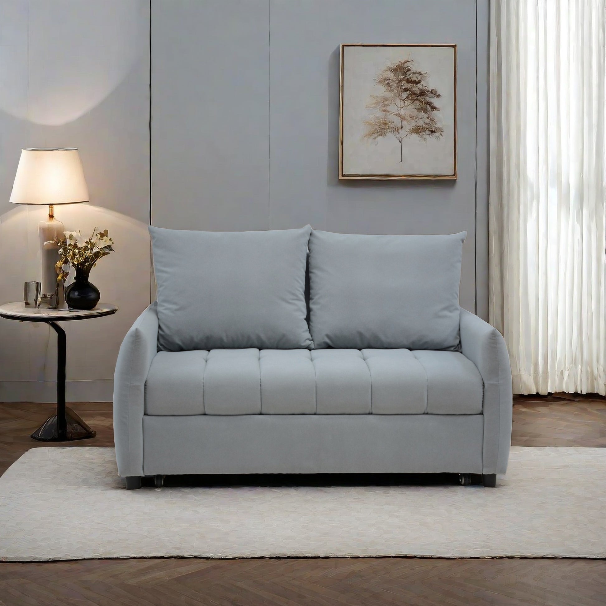 Light gray upholstered sofa bed with tufted seat and plush back cushions