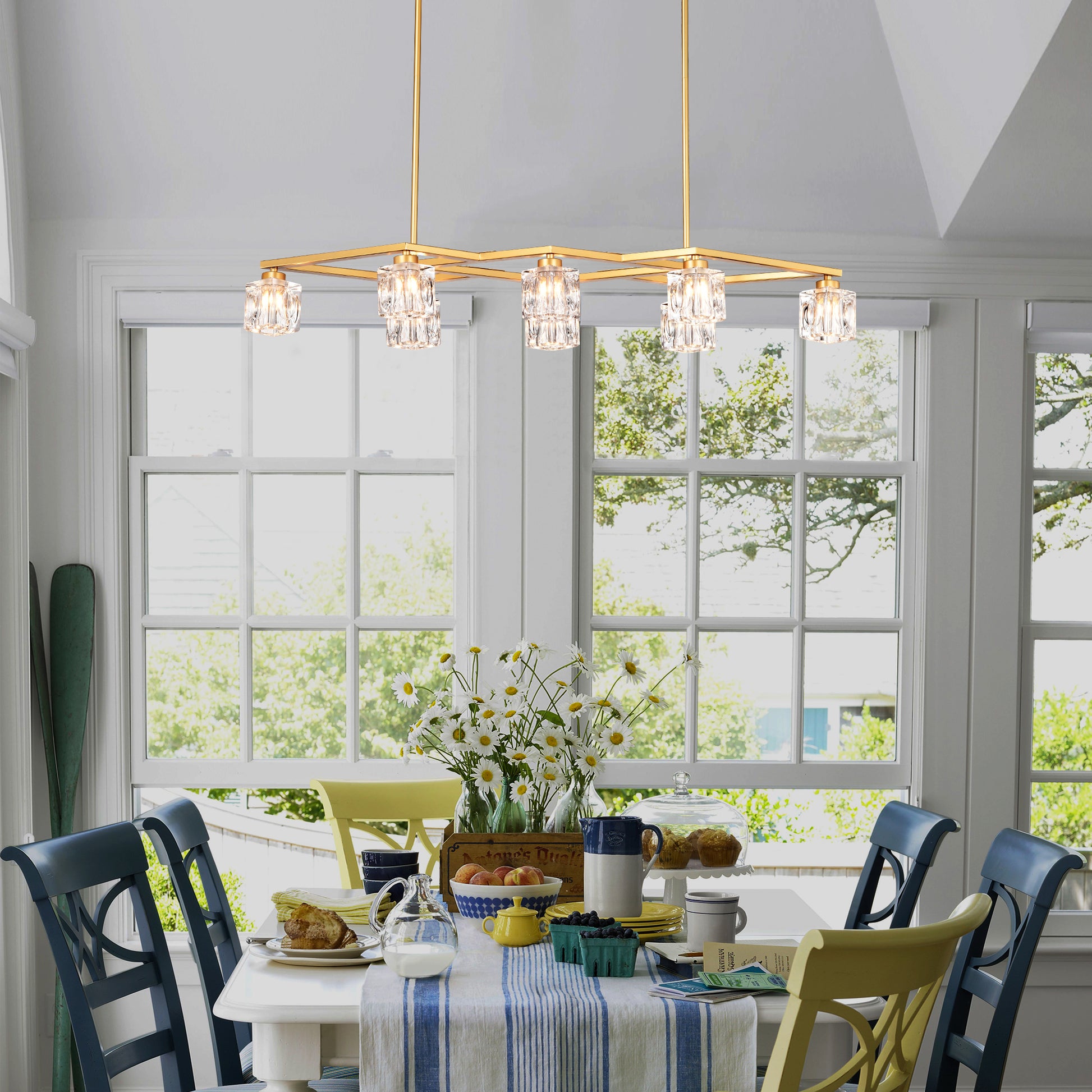 Modern gold chandelier with crystal cube shades hangs above dining table