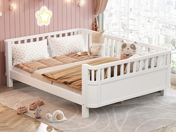 White wooden toddler bed with safety rails and plush bedding