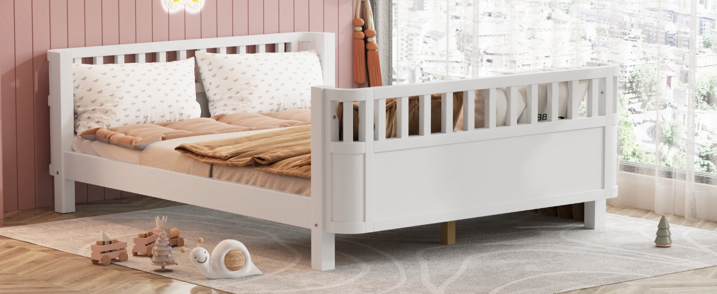 White wooden toddler bed with rail and heartpatterned pillows