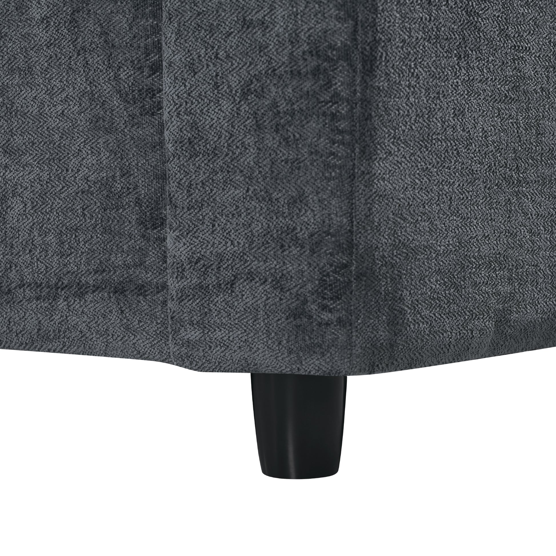Dark grey herringbone textured fabric sofa detail with a black tapered leg