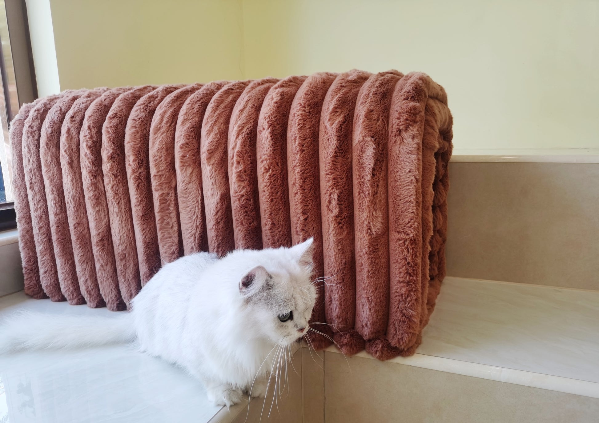 Plush rustcolored fleece throw blanket with thick ribbed texture folded on a shelf
