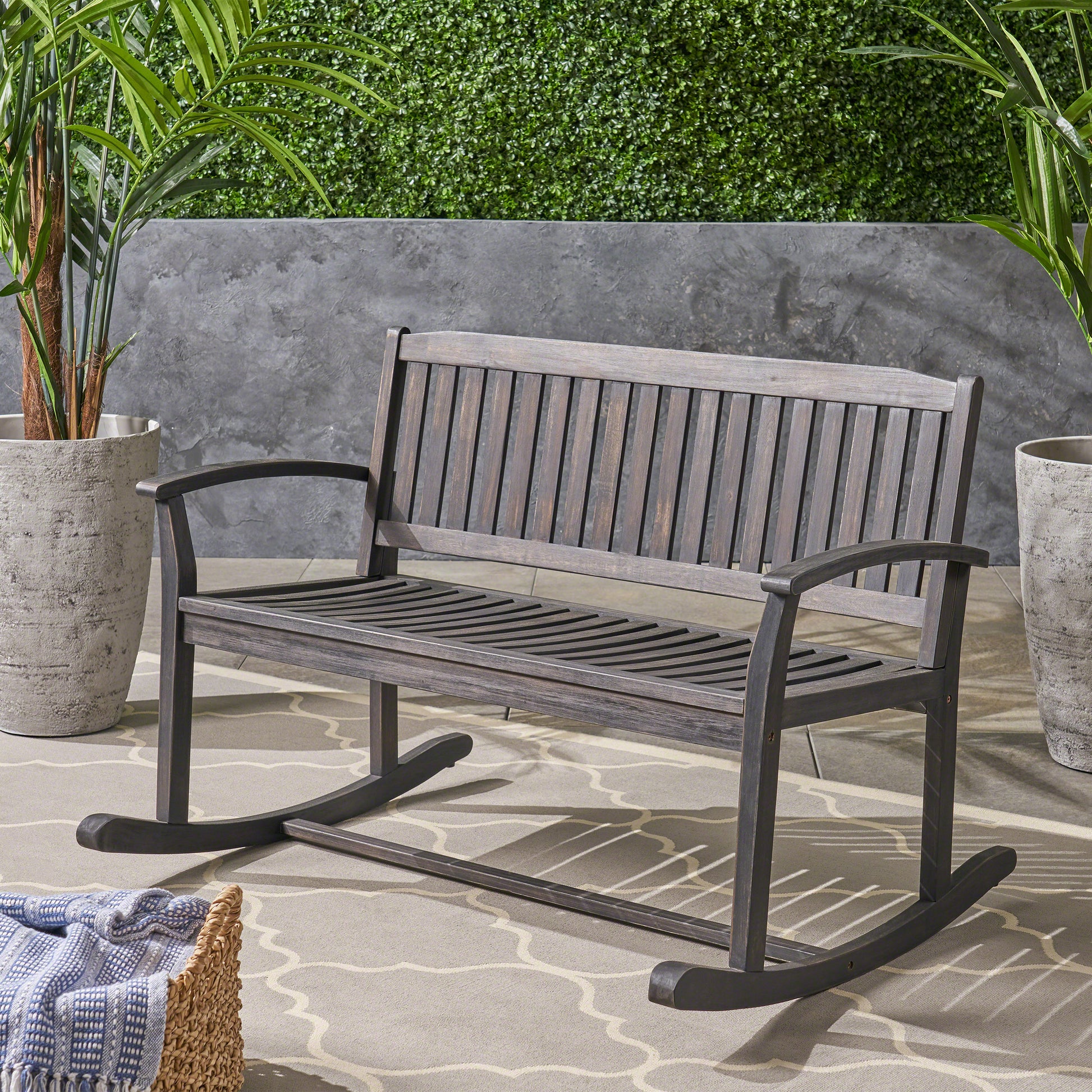 Dark gray wooden rocking bench with slatted seat and back