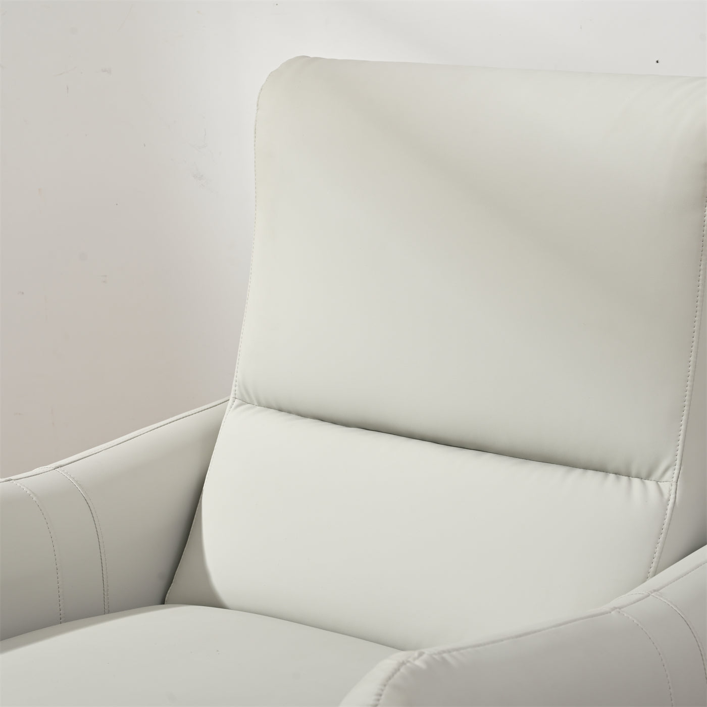 Closeup of a white leather recliner chair headrest and armrest