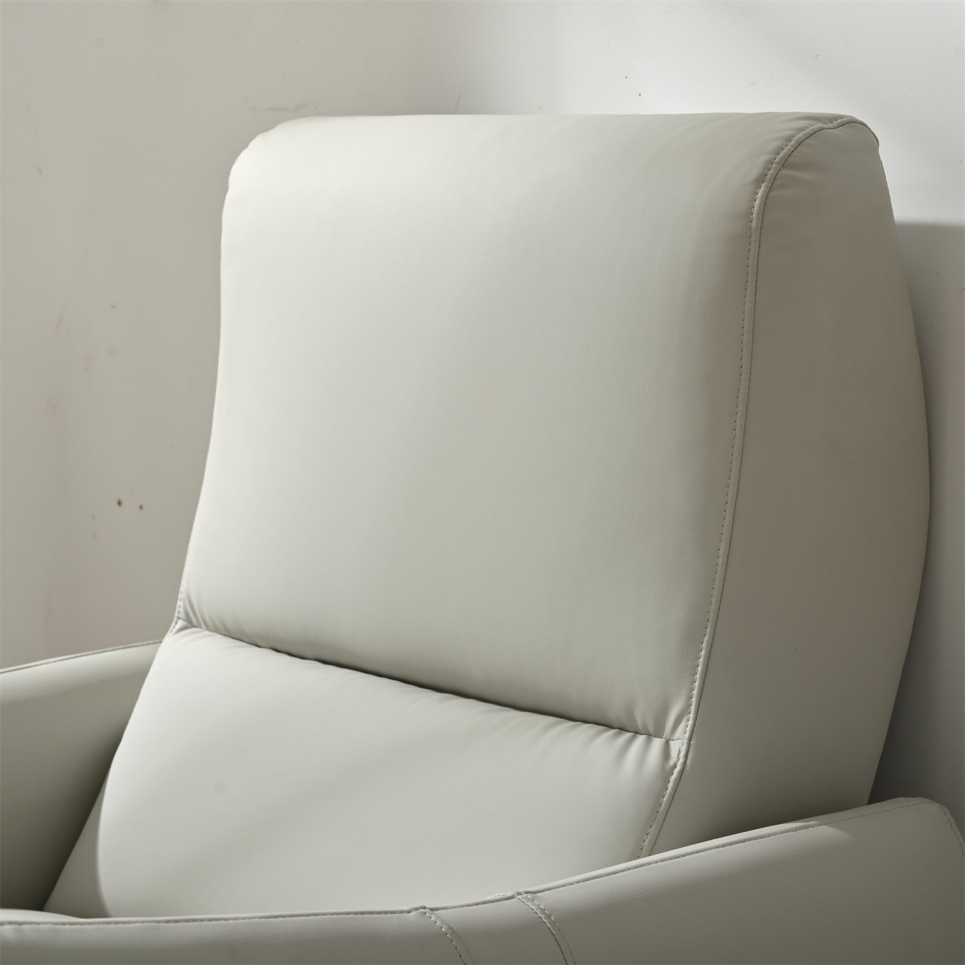 Closeup of light gray faux leather recliner headrest with subtle stitching detail