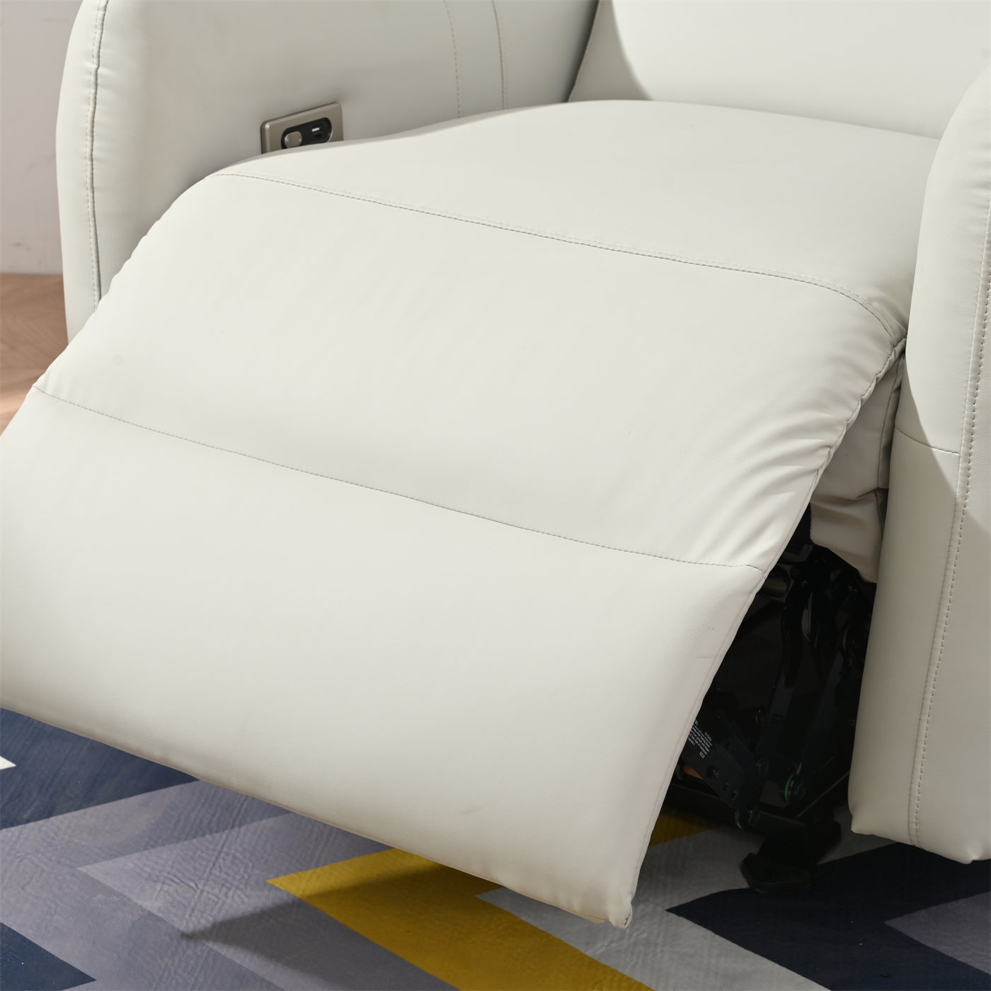 White leather recliner seat with visible power mechanism underfootrest