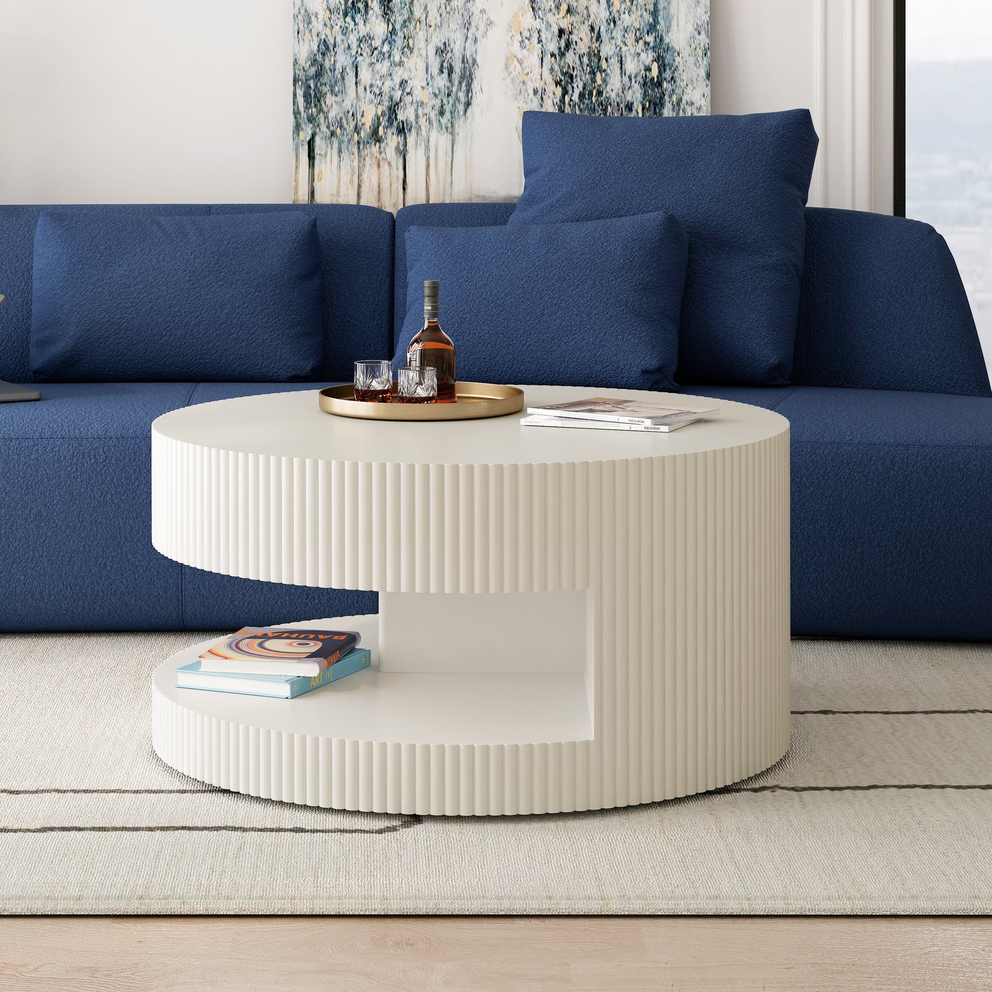 Round fluted cream coffee table with books and drinks