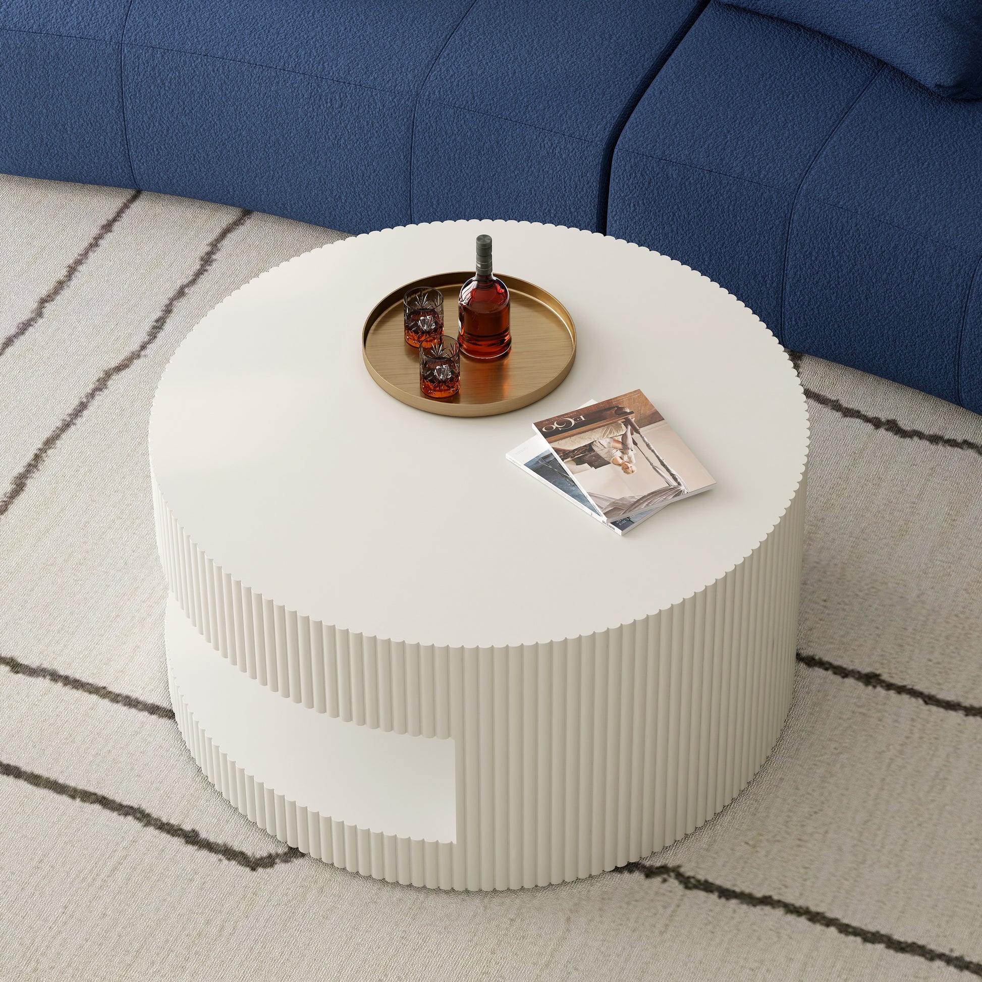 White fluted round coffee table with two shelves featuring a gold tray with whiskey bottle and glasses