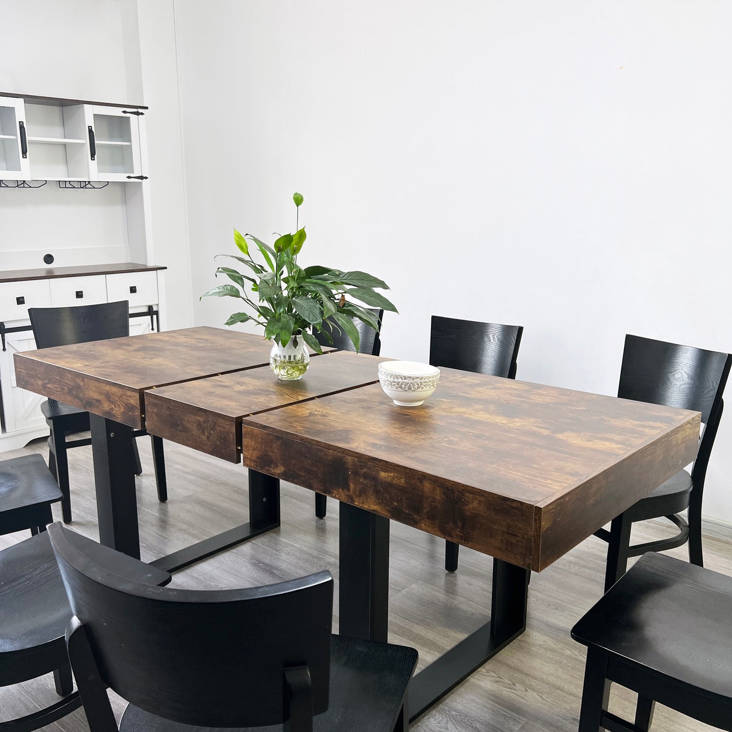 Rustic wood dining table with black metal legs and modern black chairs